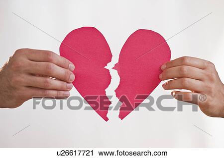 Stock Image - Two hands holding broken paper heart. Fotosearch
