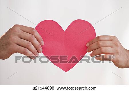 Two hands holding paper heart View Large Photo Image Stock Photo - Two hands holding paper heart. Fotosearch