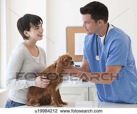 Stock Image - Vet and owner with dog. Fotosearch