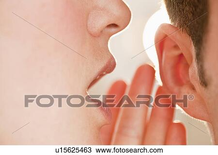 Stock Image - Whispering into ear. Fotosearch