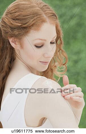 Stock Photography - Woman applying lotion. Fotosearch