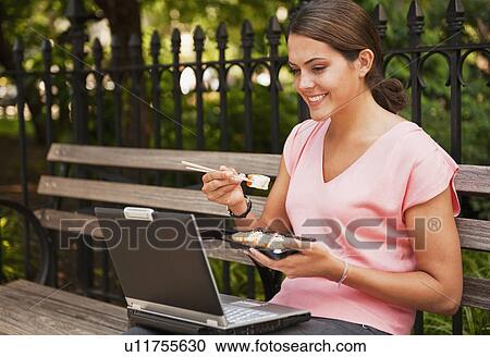 Stock Image - Woman eating Sushi. Fotosearch