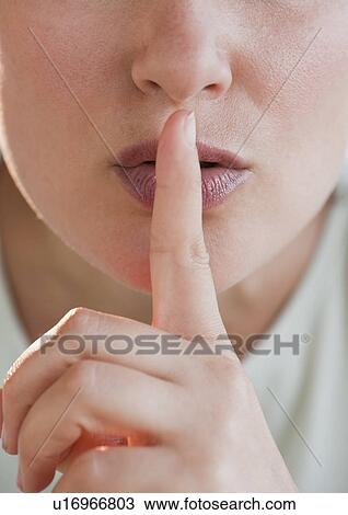 Stock Image - Woman gesturing to be quiet. Fotosearch