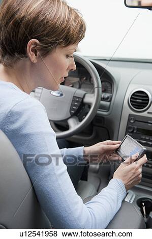 Stock Photo - Woman in car with GPS. Fotosearch