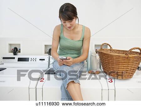Woman in laundromat View Large Photo Image Stock Image - Woman in laundromat. Fotosearch