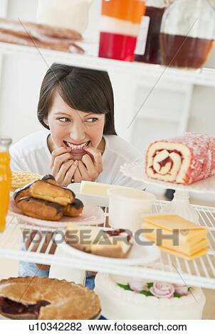 Stock Image - Woman looking at sweets. Fotosearch