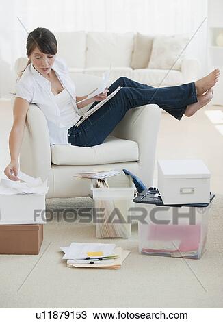 Woman organizing papers at home View Large Photo Image Stock Image - Woman organizing papers at home. Fotosearch