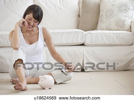 Stock Photo - Woman with piggy bank. Fotosearch