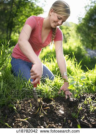 Stock Image - Woman working in garden. Fotosearch