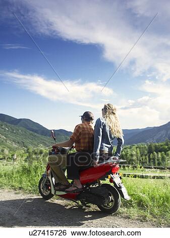 Stock Photograph - Young couple on scooter. Fotosearch