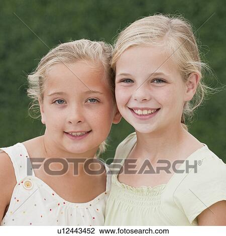 Stock Image - Young sisters smiling. Fotosearch