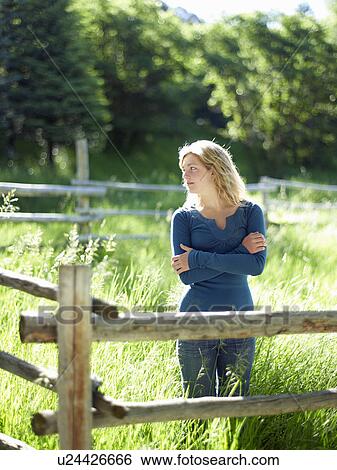 Stock Photograph - Young woman behind fence. Fotosearch