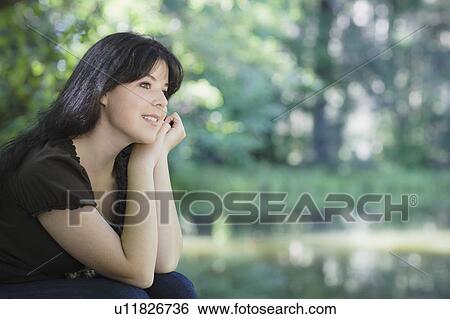 Stock Photograph - Young woman smiling in forest. Fotosearch