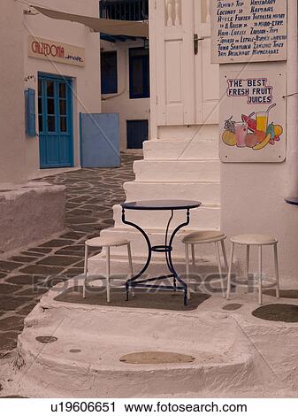 Stock Image - Empty table and stools in Mykonos Greece. Fotosearch