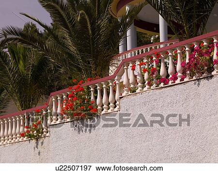 Stock Photo - Flowers overgrowing a balcony in Katakolon. Fotosearch