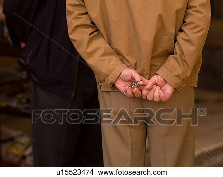 Man with his hands clasped behind his back View Large Photo Image Picture - Man with his hands clasped behind his back. Fotosearch