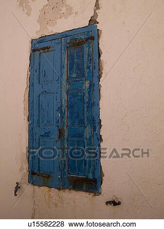Stock Photo - Weathered blue shutters in Mykonos Greece. Fotosearch
