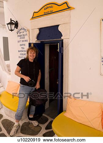 Stock Photo - Woman entering a restaurant in Mykonos Greece. Fotosearch