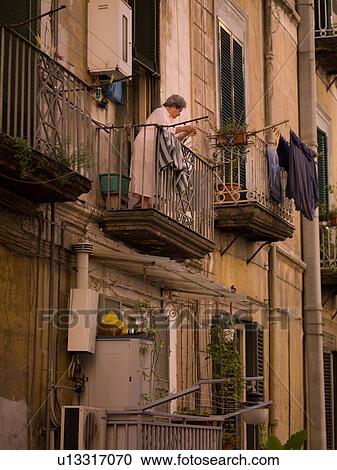 Woman standing on her balcony in Naples View Large Photo Image Stock Image - Woman standing on her balcony in Naples. Fotosearch