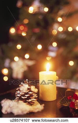 Stock Photo - A Candle and Christmas Decorations. Fotosearch