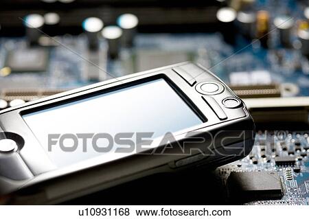Stock Photo - A cellular phone and a circuit board. Fotosearch