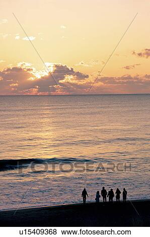Stock Photo - A Group of Friends at the Beach at Dawn. Fotosearch