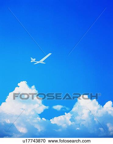 Stock Image - Airplane flying above clouds. Fotosearch