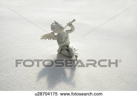 Angel figurine with musical instruments on white sand View Large Photo Image Stock Photography - Angel figurine with musical instruments on white sand. Fotosearch