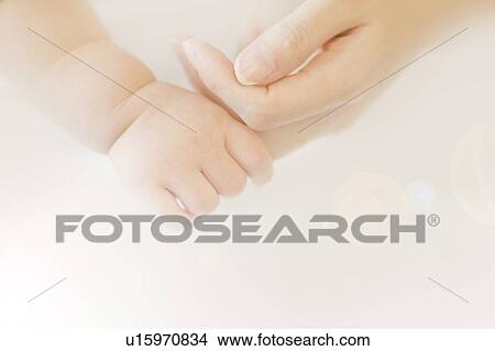 Picture - Baby holding woman's finger. Fotosearch