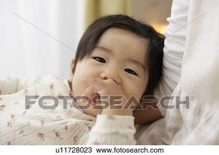 Stock Image - Baby resting on mother. Fotosearch