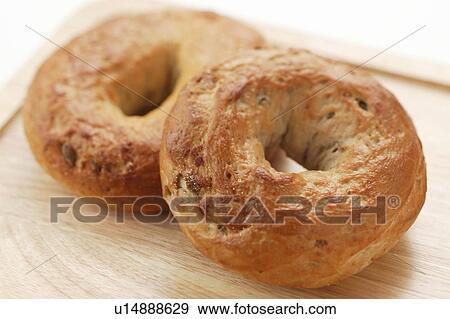 Stock Photo - Bagels on wooden tray, close up, white background. Fotosearch