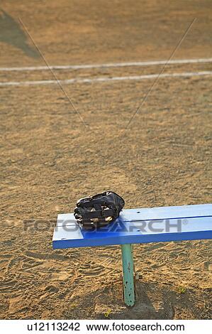 Stock Image - Baseball glove on bench. Fotosearch