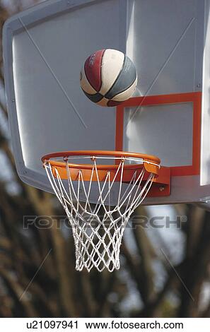 Stock Image - Basketball reaching into net. Fotosearch