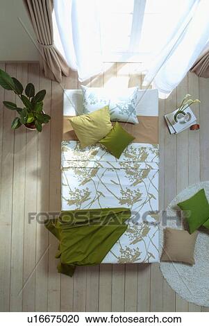 Stock Image - Bed in front of French doors. Fotosearch