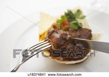 Stock Image - Beef stew in poppadum. Fotosearch