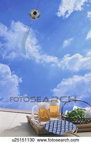 Stock Image - Beer and green soybeans against a sky background. Fotosearch