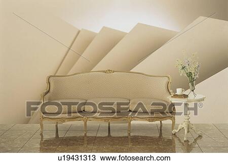 Stock Image - Beige old-fashioned sofa with side table. Fotosearch