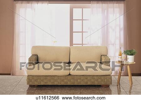 Stock Photograph - Beige sofa by open glass doors. Fotosearch