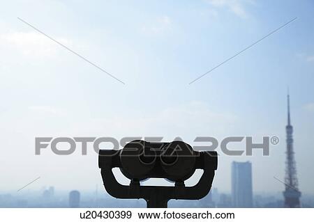 Stock Photo - Binoculars with cityscape in background, Minato ward, Tokyo Prefecture, Honshu, Japan. Fotosearch
