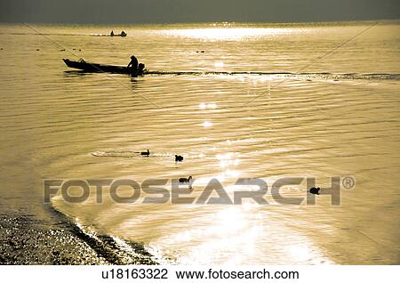 Stock Image - Boat and birds on the sparkling sea. Oarai, Oarai-machi, Ibaraki Prefecture, Japan. Fotosearch
