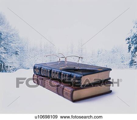 Stock Photo - Books, pen and glasses in snowy landscape. Fotosearch