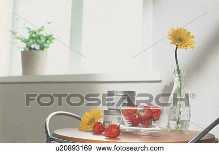 Bowl of strawberries on table with yellow flowers View Large Photo Image Stock Photo - Bowl of strawberries on table with yellow flowers. Fotosearch