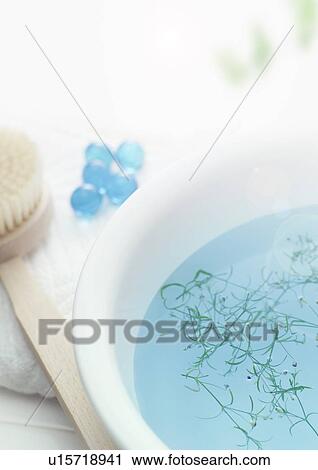 Stock Image - Bowl with herbs and toiletries on towel. Fotosearch