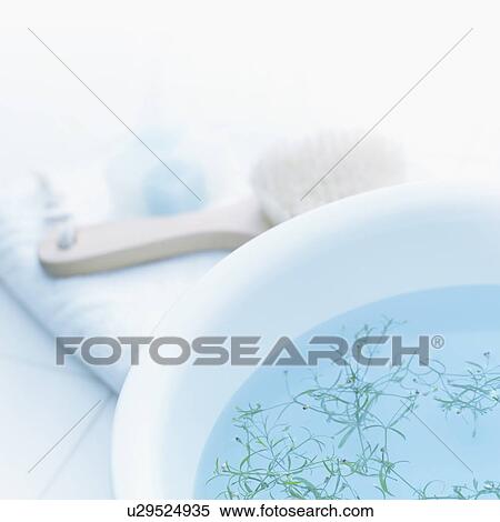 Stock Photography - Bowl with herbs and toiletries on towel. Fotosearch