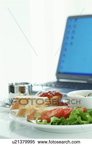 Stock Photography - Bread and salad with computer in background. Fotosearch