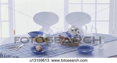 Stock Image - Breakfast on table in white room. Fotosearch