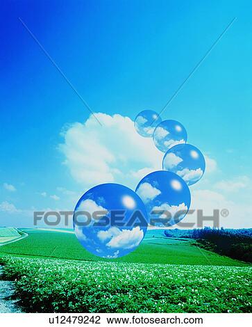 Stock Image - Bubbles containing clouds floating over a farm. Fotosearch