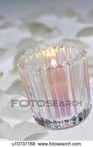 Stock Photo - Burning candle in glass, white background. Fotosearch