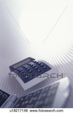 Stock Photo - Business essentials - a calculator and a mobile phone. Fotosearch
