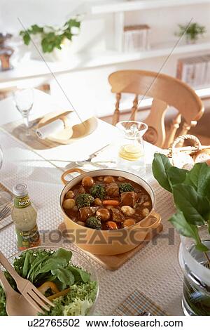 Stock Image - Casserole and salad bowl on table. Fotosearch